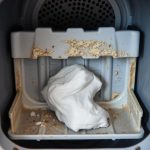 Zabrudzona szuflada pralki z widocznymi osadami z detergentu